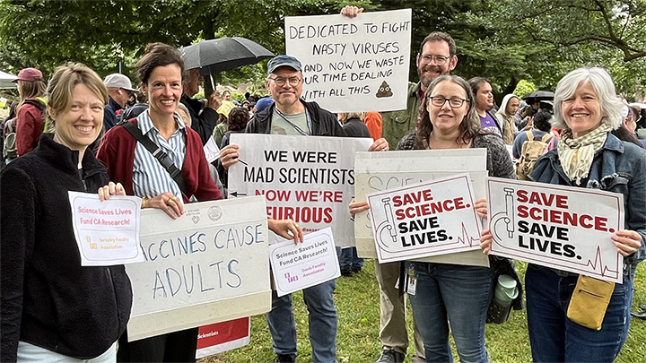 Faculty members holding signs representing the Berkeley and Davis Faculty Associations, "We were mad scientists but now we are furious", "Vaccines cause adults" and "Save Science Save Lives"